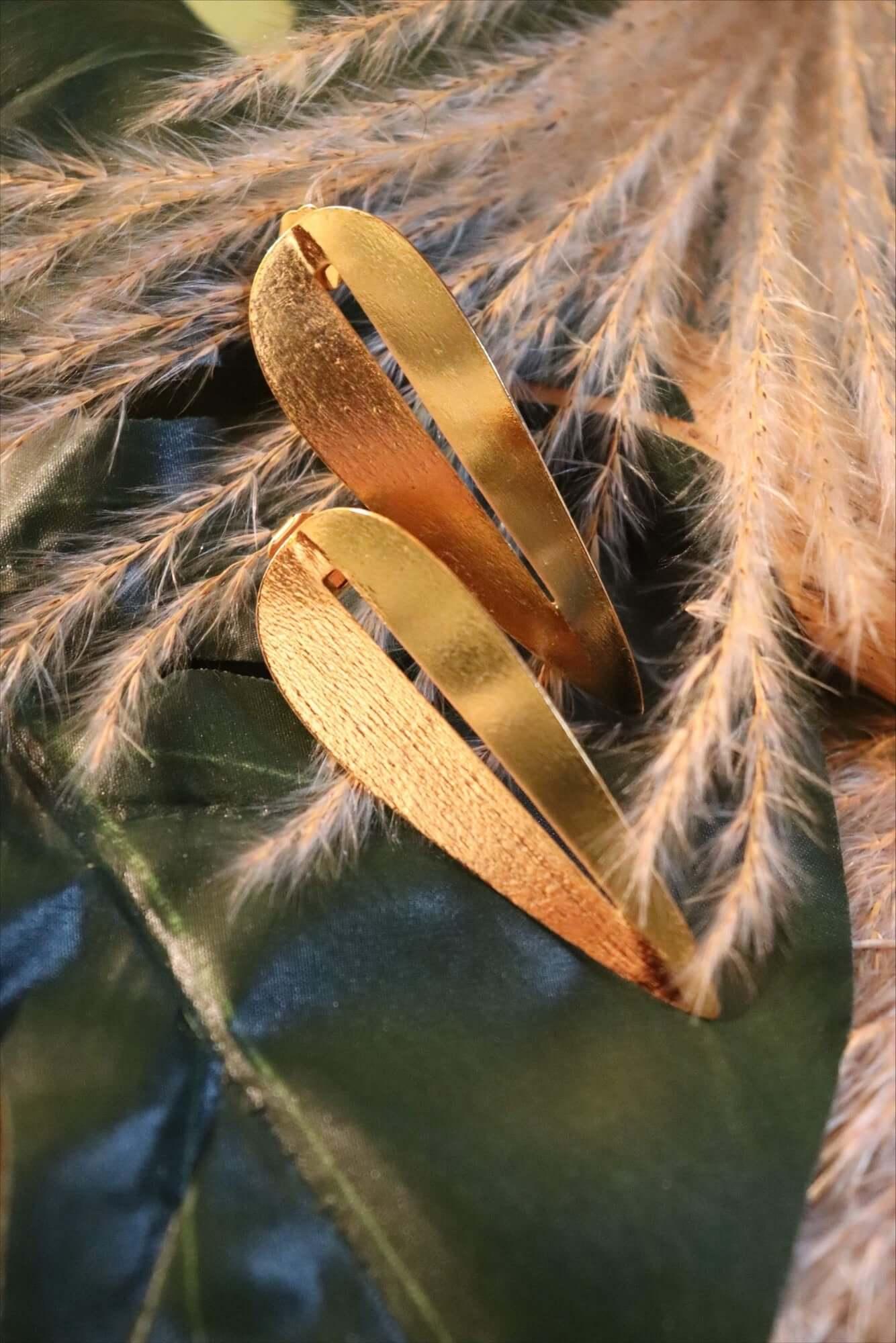 Gold textured hair clips on green satin with dried pampas grass